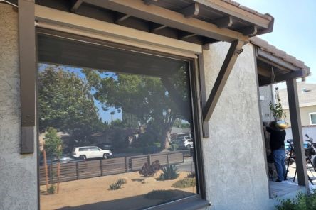 Wide shot of the window with electric automatic shades fully retracted, revealing clear glass and open outdoor view in Danville home.