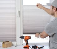 A male installing Venetian blinds